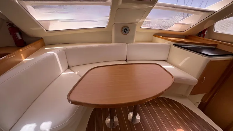 1687 Yacht Photos Pics Interior of 2006 Leopard 40 yacht with wooden table and white seating.