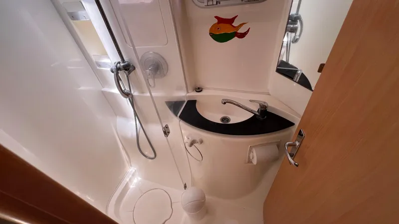 1687 Yacht Photos Pics Compact bathroom in a 2006 Leopard 40 yacht with shower and sink.