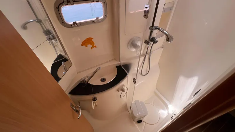 1687 Yacht Photos Pics Compact bathroom in a 2006 Leopard 40 yacht with shower, sink, and porthole.