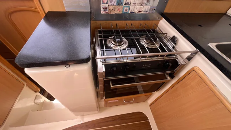 1687 Yacht Photos Pics Compact kitchen area in a 2006 Leopard 40 yacht with stove and countertop.