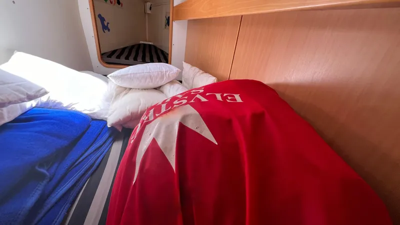 1687 Yacht Photos Pics Cozy cabin interior of 2006 Leopard 40 catamaran with colorful bedding and pillows.