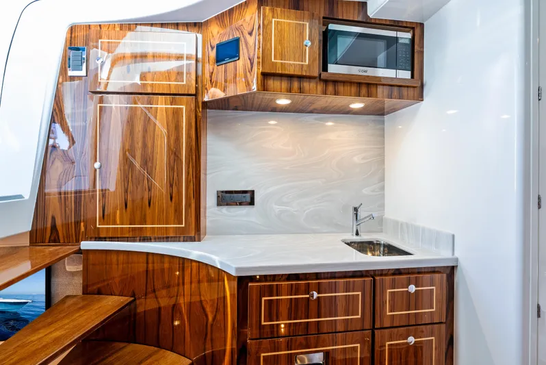 Bushwacked Yacht Photos Pics Luxurious kitchen area in 2025 HCB 56 Suenos GIX yacht with wood cabinetry and modern appliances.