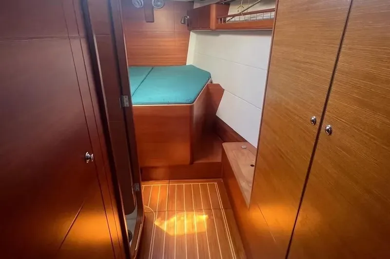 Arya Yacht Photos Pics Cozy cabin interior of 2010 X Yachts X-50 with wooden finish and teal bedding.