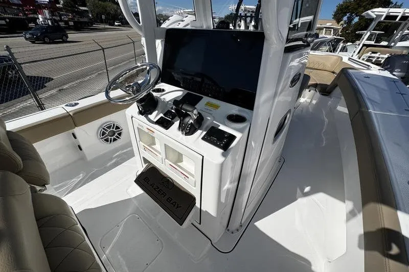  Yacht Photos Pics 2026 Blazer Bay Makaira 2800 boat cockpit with steering wheel and control panel.