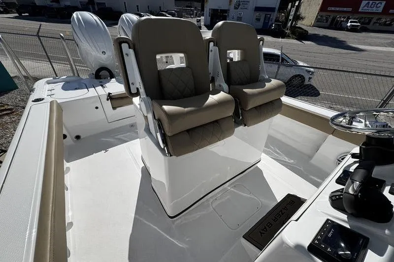  Yacht Photos Pics 2026 Blazer Bay Makaira 2800 boat interior with dual cushioned seats and steering console.