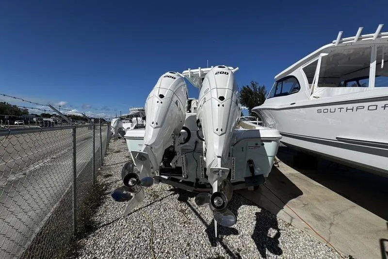  Yacht Photos Pics 2026 Blazer Bay Makaira 2800 with dual outboard engines, parked beside a road.