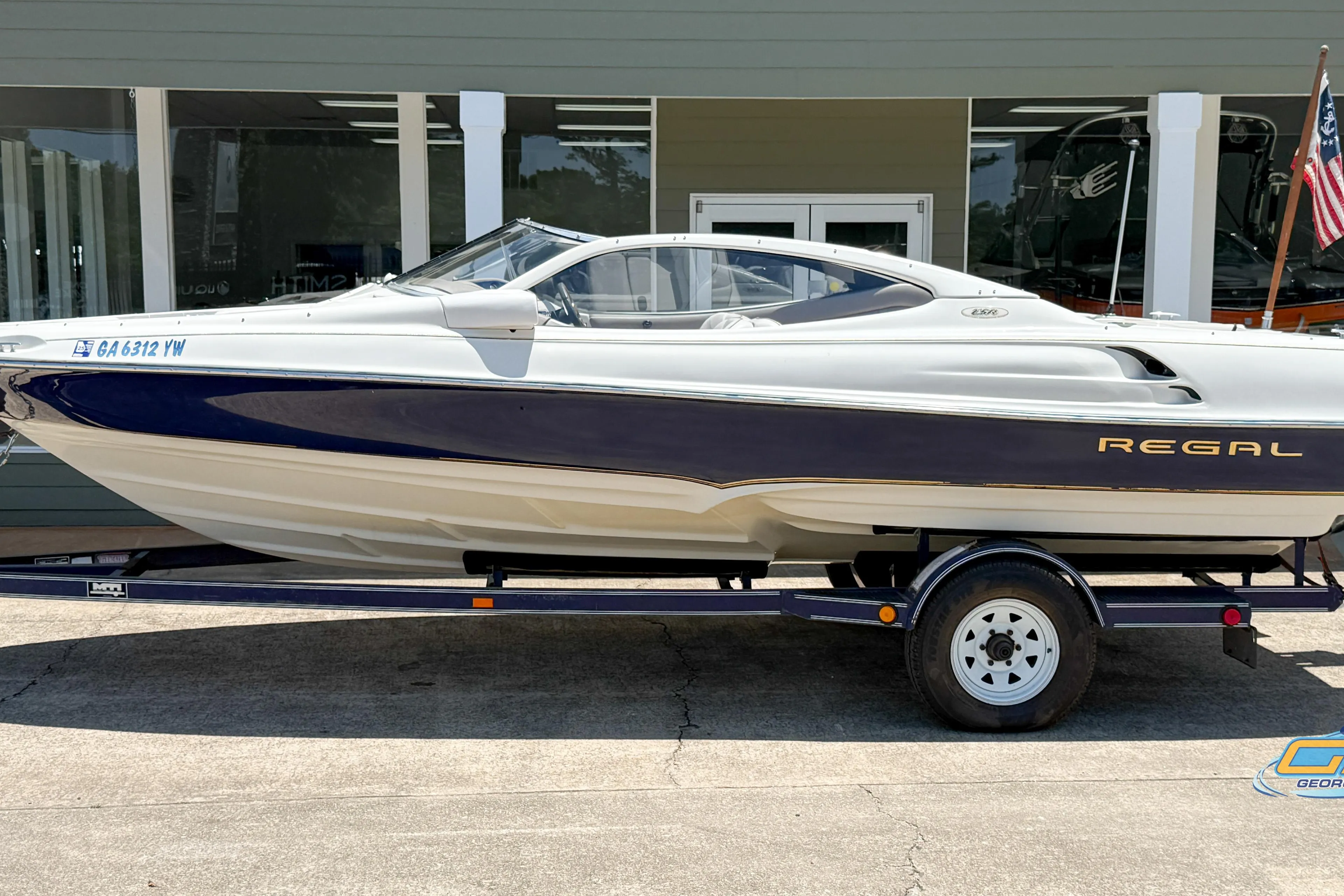1998 Regal 2100 LSR boat on trailer, parked outside dealership.