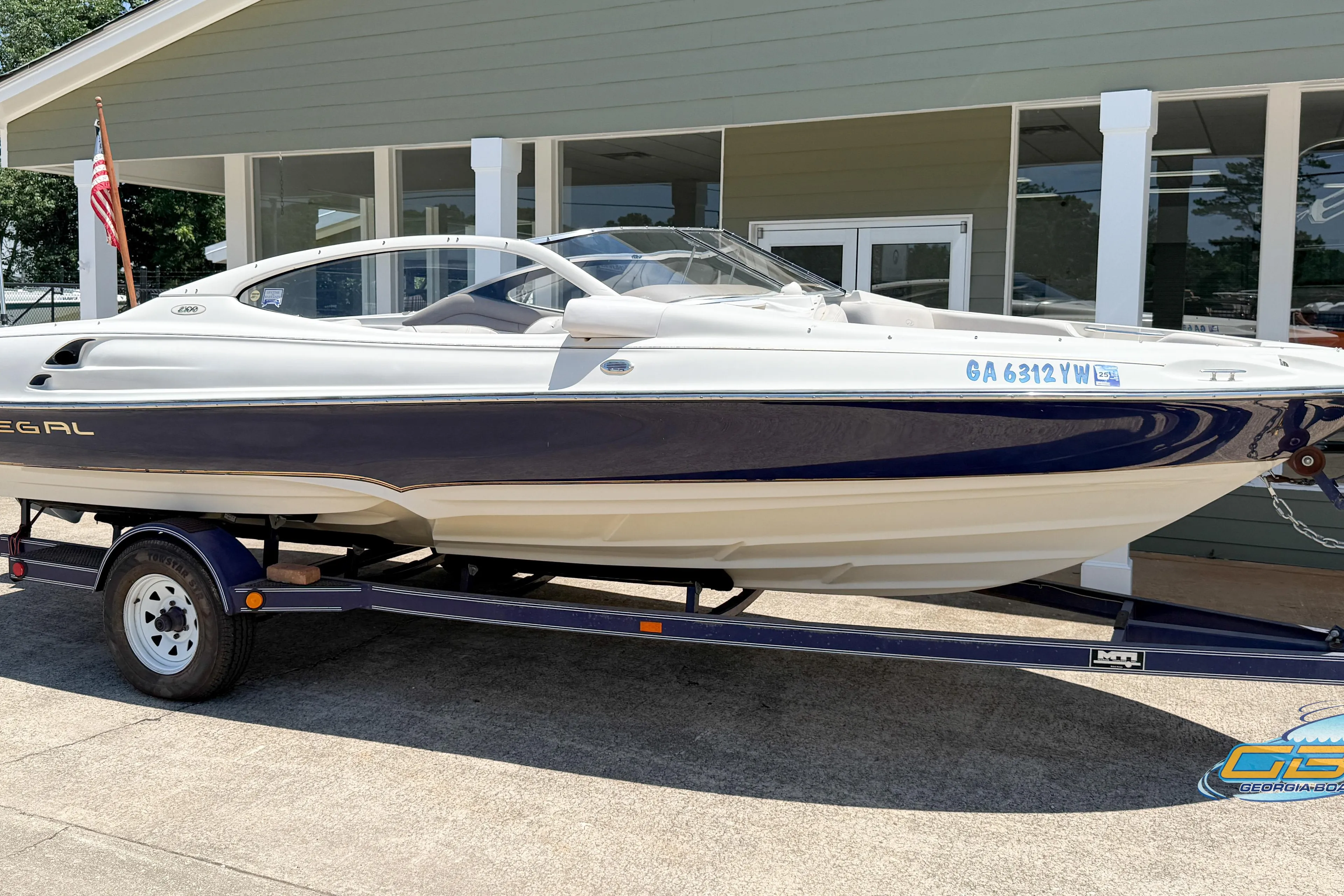 1998 Regal 2100 LSR boat on trailer, parked outside a building.