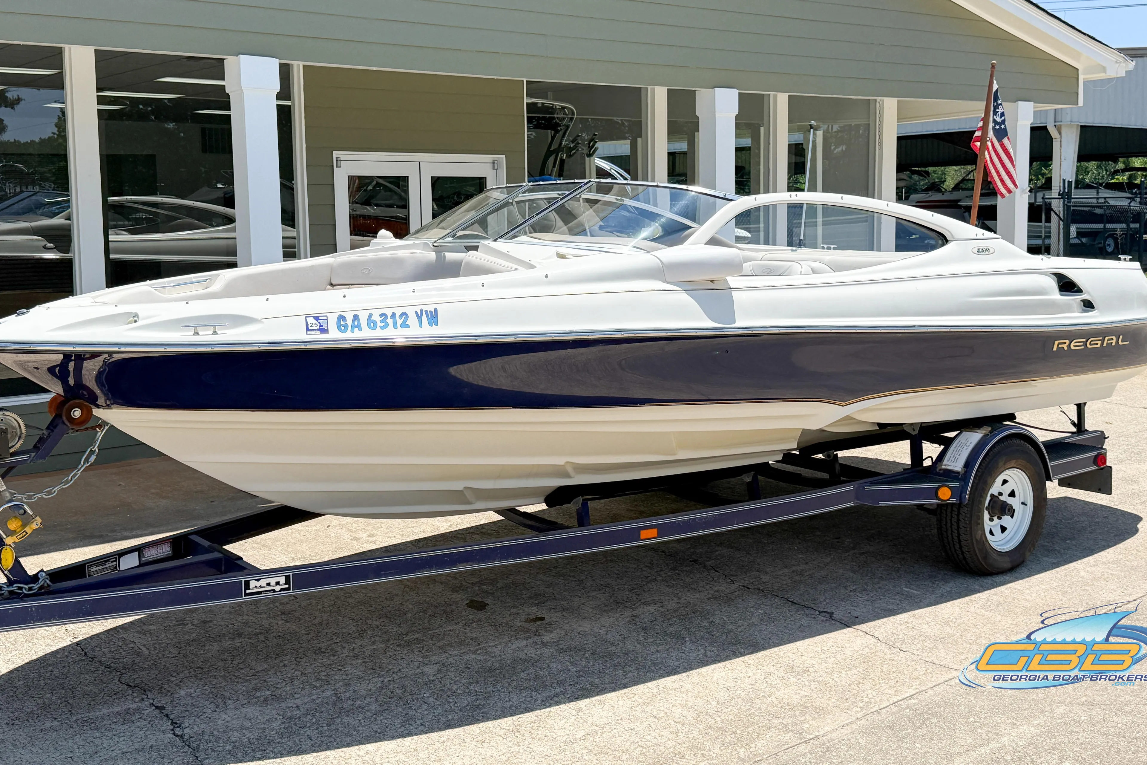 1998 Regal 2100 LSR boat on trailer, parked outside a building.