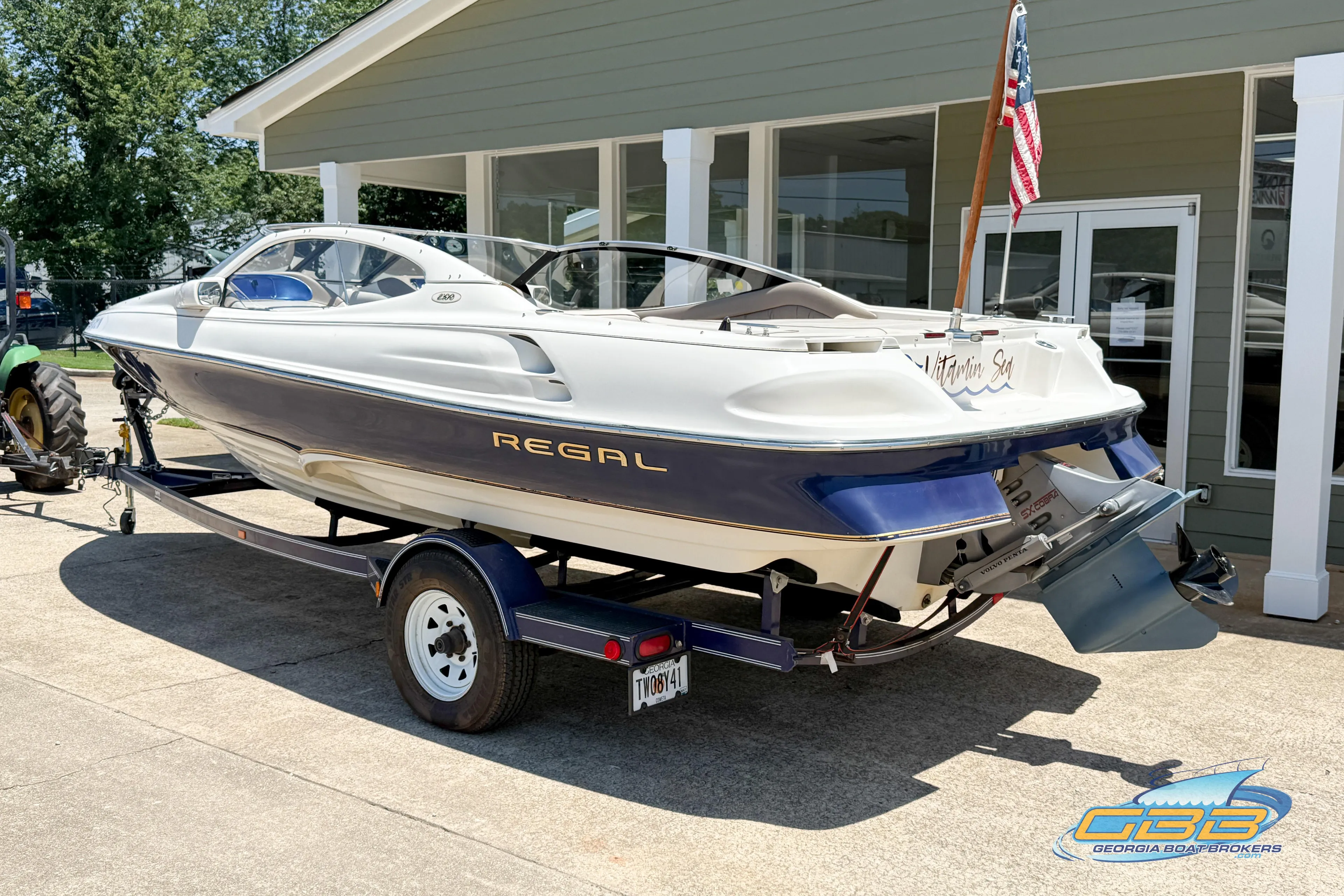 1998 Regal 2100 LSR boat on trailer, parked outside a building.