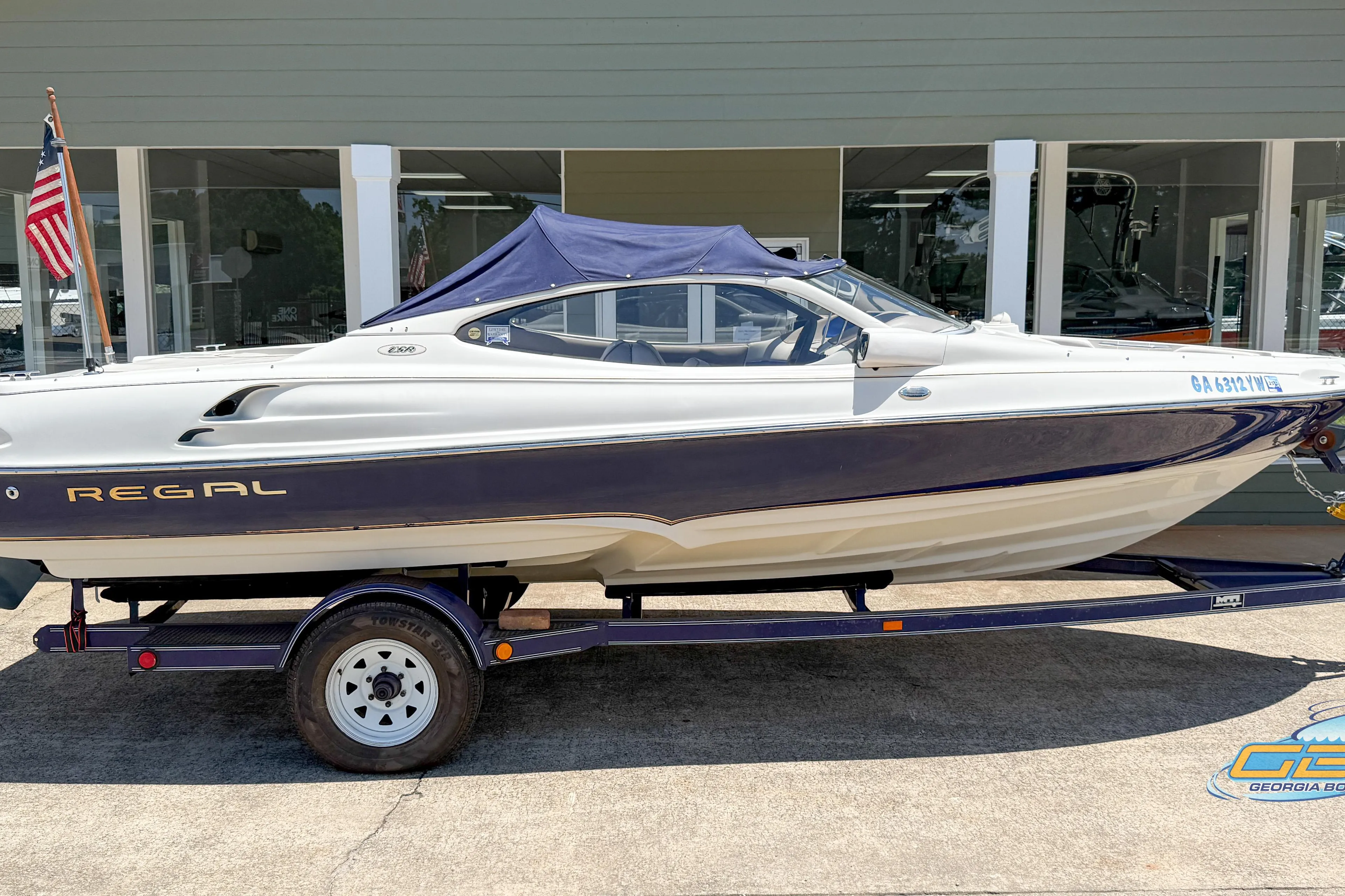 1998 Regal 2100 LSR boat on trailer, displayed outdoors with American flag.