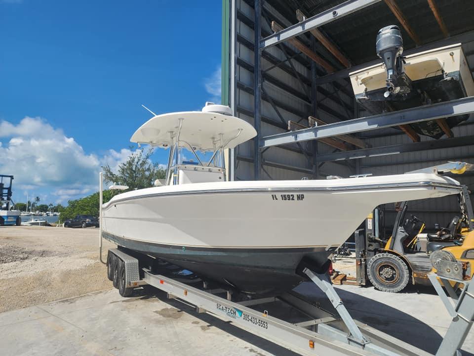 2006 Stamas 290 Tarpon boat on trailer in sunny marina setting.