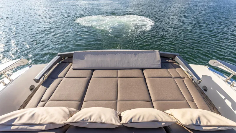 Pershing 70 White Yacht Photos Pics Luxury sunbed on 2016 Pershing 70 yacht overlooking serene water.