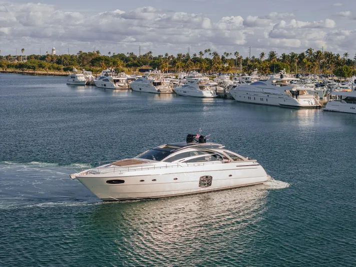 Pershing 70 White Yacht Photos Pics 2016 Pershing 70 yacht cruising in a marina with other luxury boats.