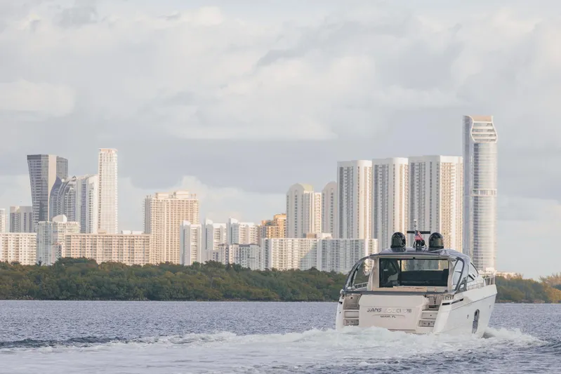 Pershing 70 White Yacht Photos Pics 2016 Pershing 70 yacht cruising near a city skyline with modern skyscrapers.
