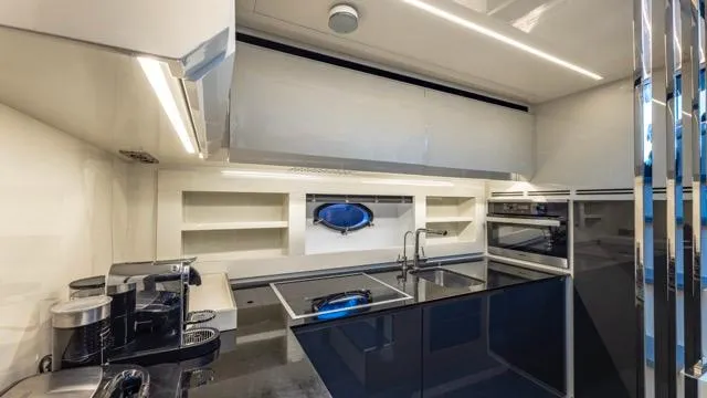 Pershing 70 White Yacht Photos Pics Modern kitchen interior on a 2016 Pershing 70 yacht, featuring sleek cabinetry and appliances.
