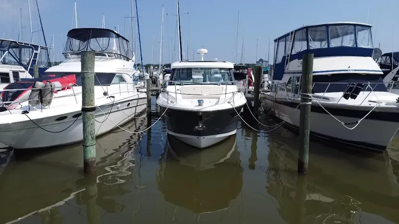  Yacht Photos Pics 2020 Regal 38 Grande Coupe docked between two boats at a marina.