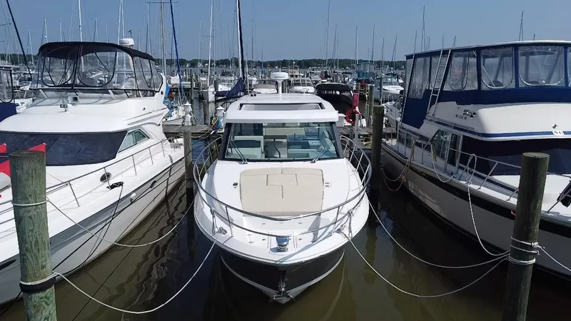  Yacht Photos Pics 2020 Regal 38 Grande Coupe docked between two boats in a marina.