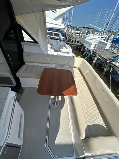  Yacht Photos Pics 2020 Regal 38 Grande Coupe yacht interior with seating and wooden table at marina.