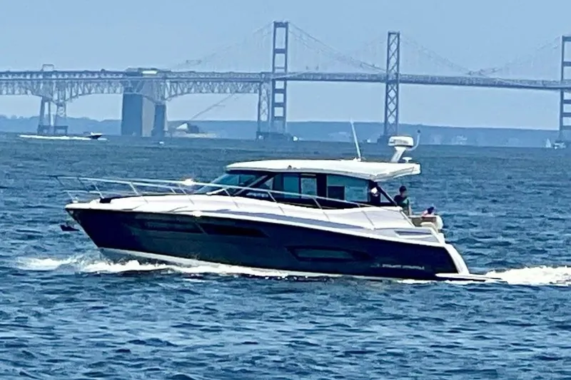  Yacht Photos Pics 2020 Regal 38 Grande Coupe cruising on water with bridge in background.