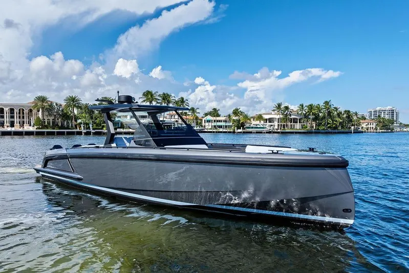 Not His Yacht Photos Pics 2024 Vanquish Yachts 40 on serene water with luxury waterfront homes in the background.