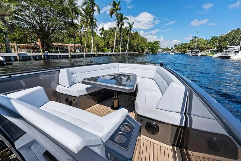 Not His Yacht Photos Pics Luxurious 2024 Vanquish Yachts 40 interior with elegant seating and table, cruising on a scenic waterway.