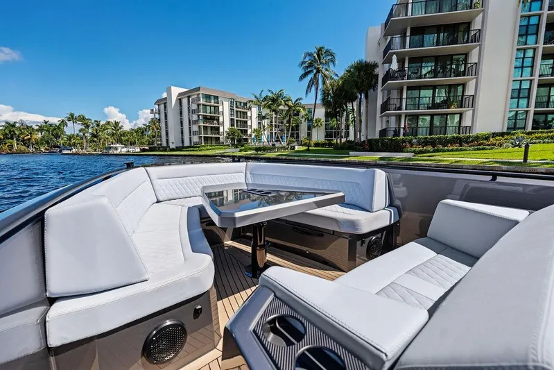 Not His Yacht Photos Pics Luxurious 2024 Vanquish Yachts 40 with elegant seating, docked near waterfront apartments.