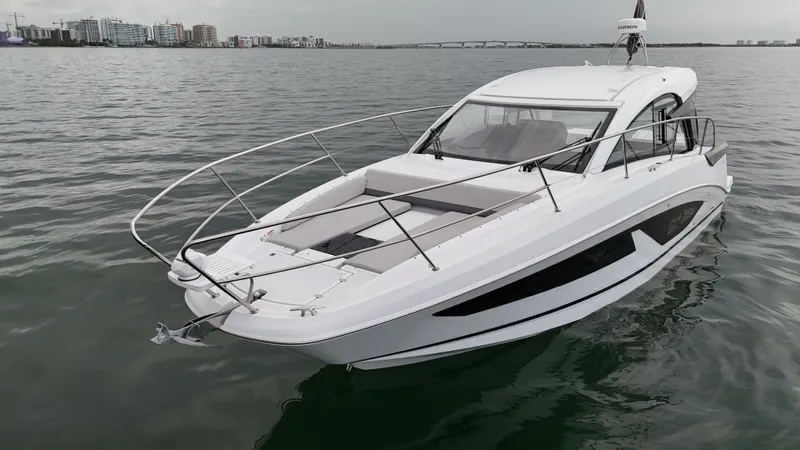  Yacht Photos Pics 2025 Beneteau Gran Turismo 36 yacht on calm water, cityscape in background.
