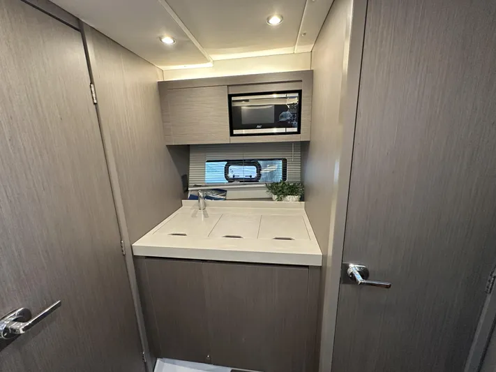  Yacht Photos Pics Modern kitchenette in 2025 Beneteau Gran Turismo 36 yacht, featuring sleek cabinetry and built-in microwave.