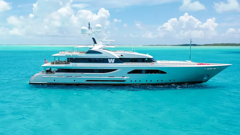 W Yacht Photos Pics Luxurious 2013 Feadship yacht cruising in clear turquoise waters under a bright blue sky.