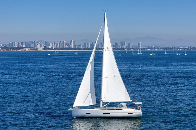 Tuanis Yacht Photos Pics 2023 Bavaria C50 sailboat on ocean with city skyline in background.