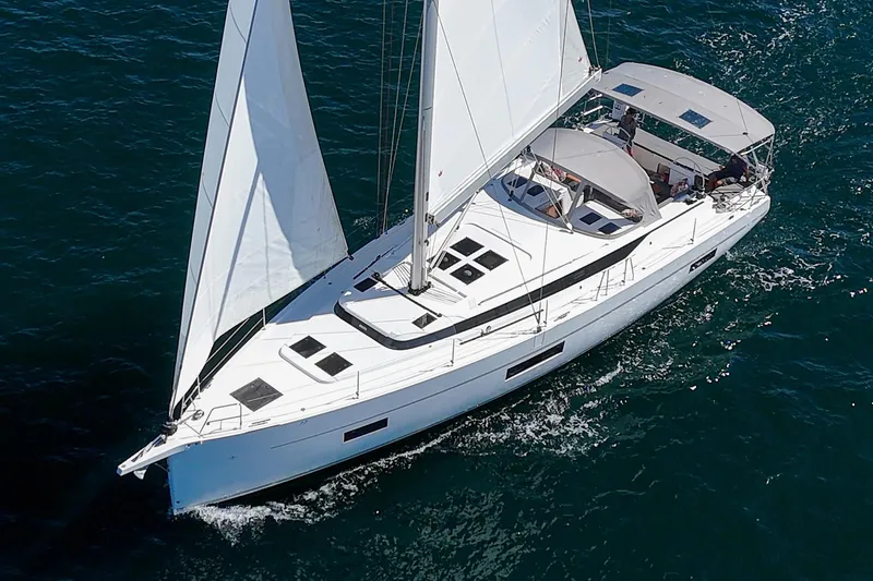 Tuanis Yacht Photos Pics 2023 Bavaria C50 sailing yacht cruising on open water, aerial view.