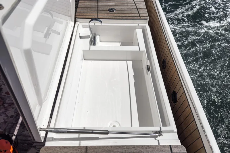 Tuanis Yacht Photos Pics 2023 Bavaria C50 yacht deck with open storage compartment and ocean view.