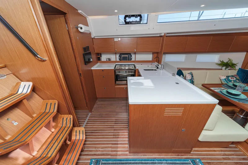 Tuanis Yacht Photos Pics Luxurious interior of 2023 Bavaria C50 yacht with modern kitchen and dining area.