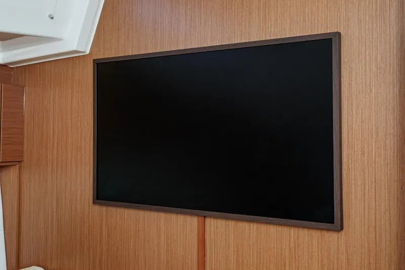 Tuanis Yacht Photos Pics Flat-screen TV on wooden wall inside 2023 Bavaria C50 yacht interior.