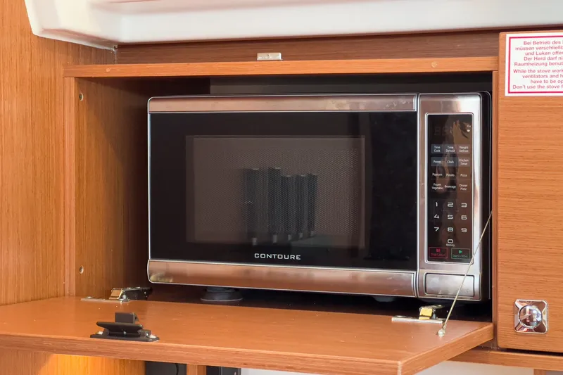 Tuanis Yacht Photos Pics Microwave in Bavaria C50 yacht kitchen, 2023 model, with wooden cabinetry.