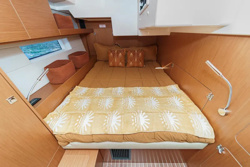 Tuanis Yacht Photos Pics Cozy cabin interior of 2023 Bavaria C50 yacht with comfortable bedding and wooden finish.