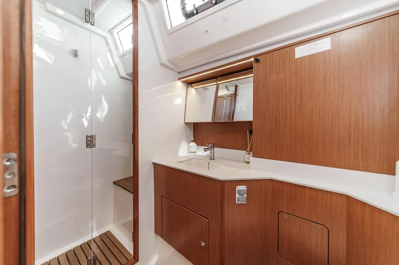 Tuanis Yacht Photos Pics Luxurious 2023 Bavaria C50 yacht bathroom with wooden cabinetry and modern fixtures.