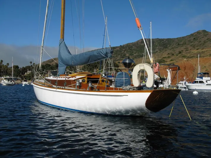 Merrywing Yacht Photos Pics Vintage 1962 Custom Merrywing sailboat anchored in scenic harbor with hills in background.