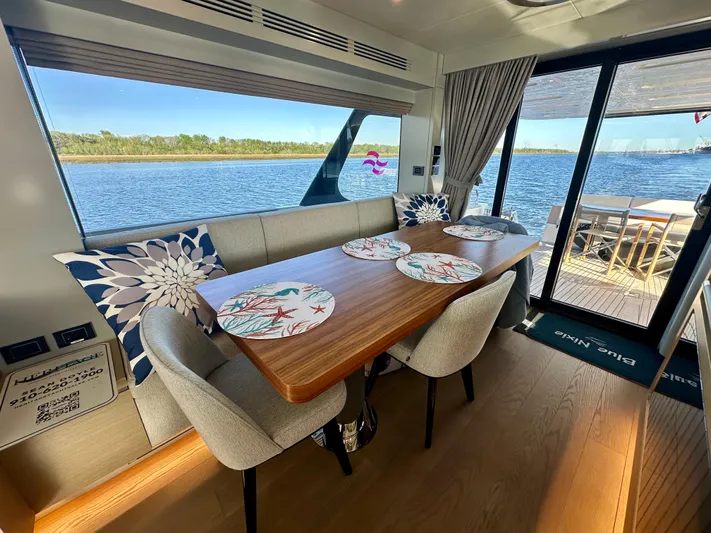  Yacht Photos Pics Luxurious interior of 2024 Sirena 68 yacht with elegant dining area and scenic water view.