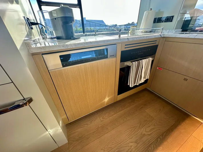  Yacht Photos Pics 2024 Sirena 68 yacht kitchen with modern appliances and wooden cabinetry.