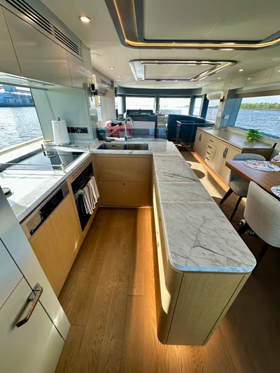  Yacht Photos Pics Luxurious 2024 Sirena 68 yacht interior with modern kitchen and elegant dining area.