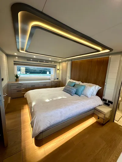  Yacht Photos Pics Luxurious bedroom interior of 2024 Sirena 68 yacht with modern lighting and elegant decor.
