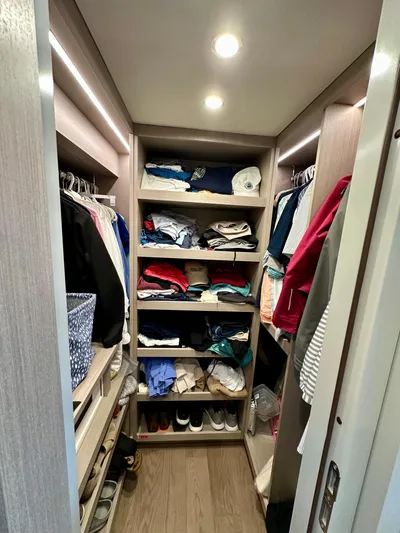  Yacht Photos Pics Spacious walk-in closet with organized shelves and hanging clothes in a 2024 Sirena 68 yacht.