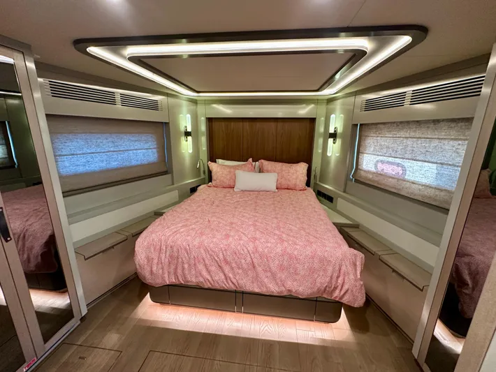  Yacht Photos Pics Luxurious bedroom interior of 2024 Sirena 68 yacht with modern lighting and cozy bedding.