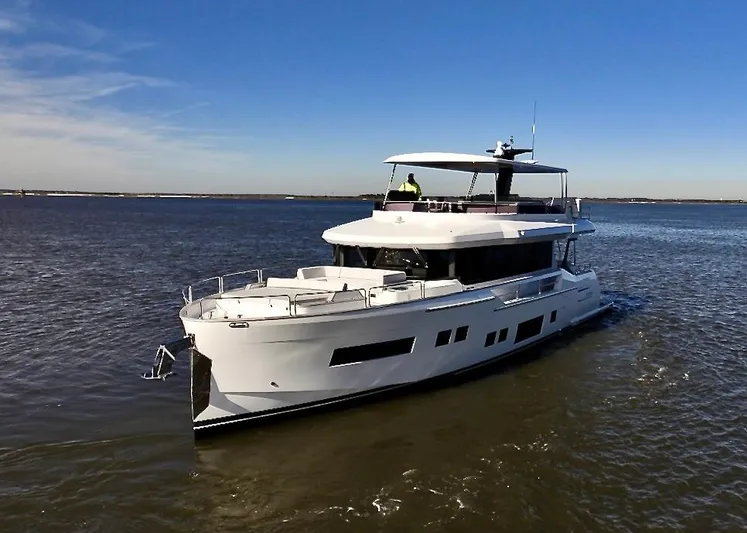  Yacht Photos Pics 2024 Sirena 68 yacht cruising on open water under a clear blue sky.