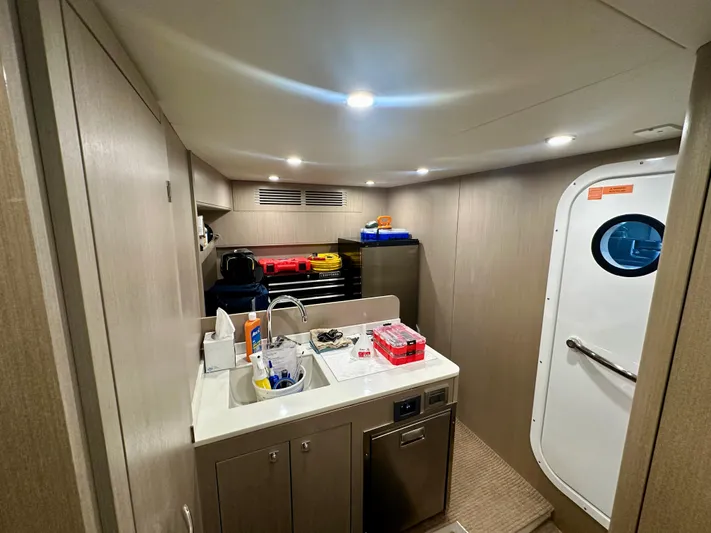  Yacht Photos Pics 2024 Sirena 68 yacht interior with kitchenette, sink, and storage, featuring modern design and lighting.
