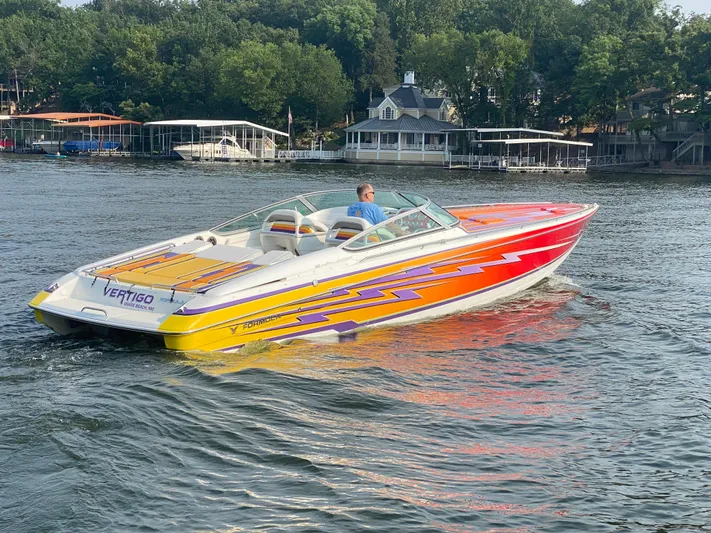  Yacht Photos Pics 2006 Formula 353 FASTech speedboat with vibrant graphics cruising on a lake.