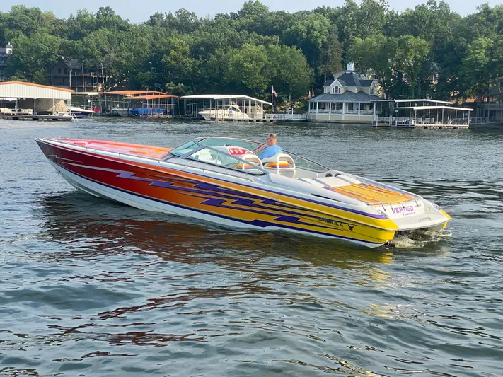  Yacht Photos Pics 2006 Formula 353 FASTech speedboat with vibrant graphics cruising on a lake.