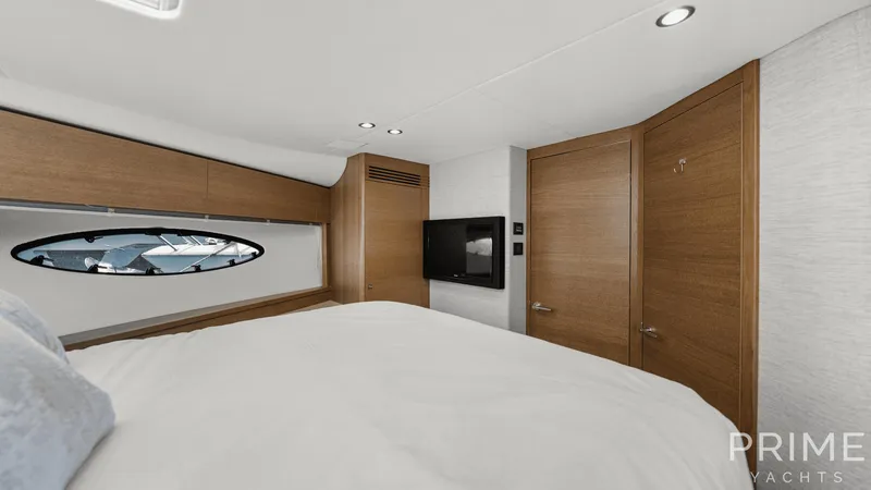  Yacht Photos Pics Luxurious cabin interior of 2019 Princess F49 yacht with wood accents and porthole view.